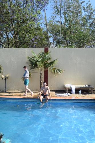 two men are playing in a swimming pool at Stasumo House Arusha in Arusha