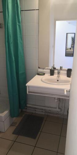 a bathroom with a sink and a mirror at Studio équipé Clim TV Wifi in Saint-Denis
