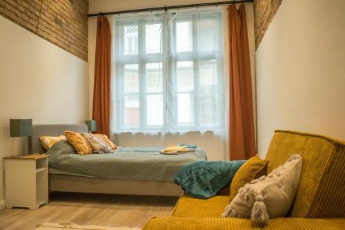 a bedroom with a bed and a window and a chair at Downtown apartment 2 minutes from Opera House in Budapest