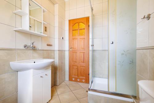 un bagno con lavandino e doccia di Dom Gościnny Relax a Rewal