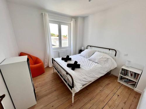 a bedroom with a bed with two crosses on it at Superbe villa avec piscine à 10 min du centre in La Rochelle