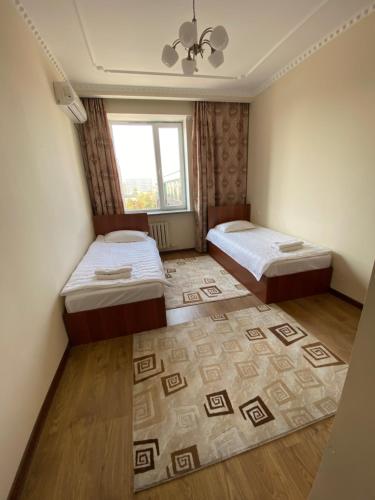 1 dormitorio con 2 camas y ventana en Narke Hostel en Bishkek