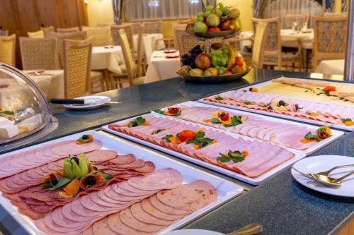 un buffet con diversi vassoi di cibo su un tavolo di Gästehaus Rudolfo a Zell am See