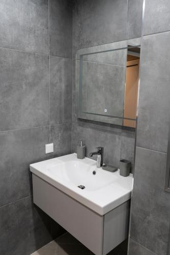 a bathroom with a white sink and a mirror at Urban Elegance by Eagles' Bridge in Sofia