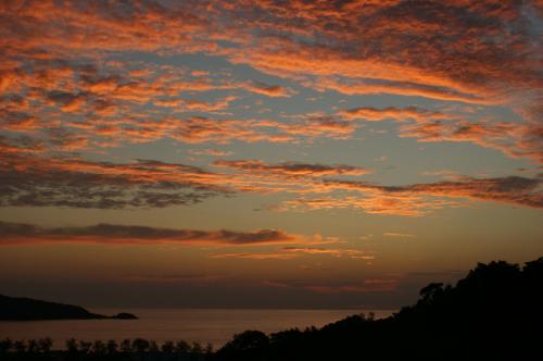 a sunset over a body of water at Prince Edouard Apartments & Resort SHA extra plus in Patong Beach