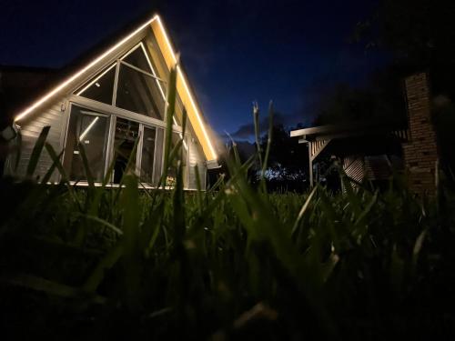 ein nachts beleuchtetes Haus mit Gras im Vordergrund in der Unterkunft Ensagardenbungalov in Kartepe