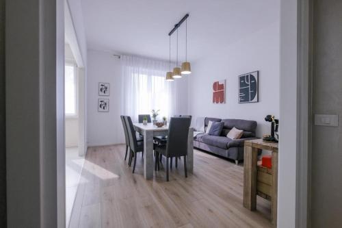 a dining room and living room with a table and chairs at SBS Room Rental in Bergamo