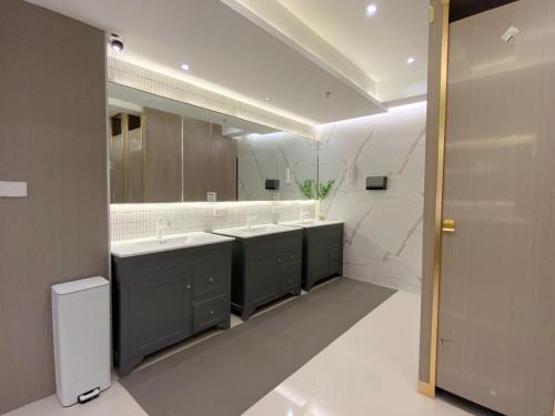 La salle de bains est pourvue de 2 lavabos et d'un grand miroir. dans l'établissement Suzhou MeetU Intl Youth Hostel, à Suzhou