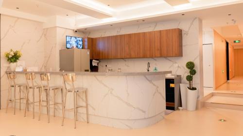 una cucina con ripiani in marmo e sgabelli di Suzhou MeetU Intl Youth Hostel a Suzhou