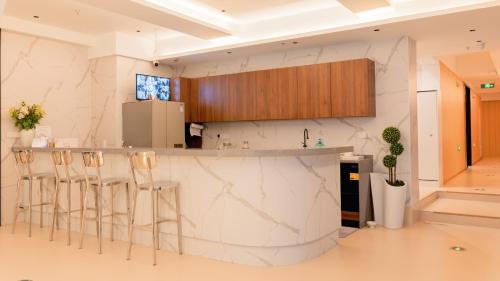 a kitchen with marble counter tops and stools at Suzhou MeetU Intl Youth Hostel in Suzhou