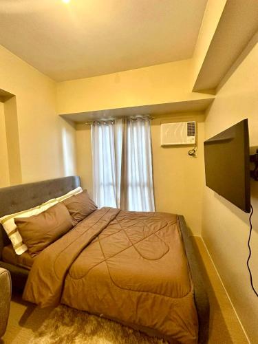 a bedroom with a bed in front of a window at AVIDA ATRIA TOWER 3 Unit 3-320 in Iloilo City