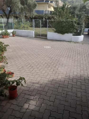 a brick courtyard with plants and a fence at AceroRosso B&B in Salerno