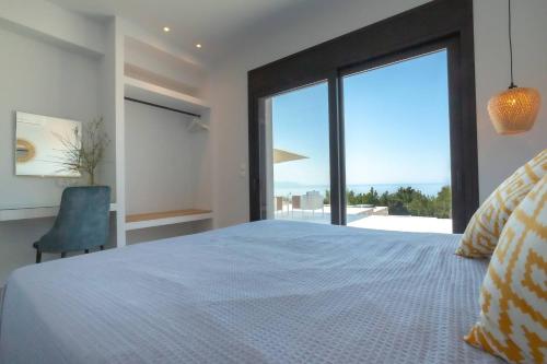 a bedroom with a large bed and a large window at Villa Vista Mare Lourdata Kefalonia in Lourdhata