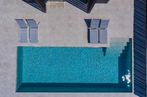 an overhead view of a pool with chairs and water at Villa Vista Mare Lourdata Kefalonia in Lourdhata