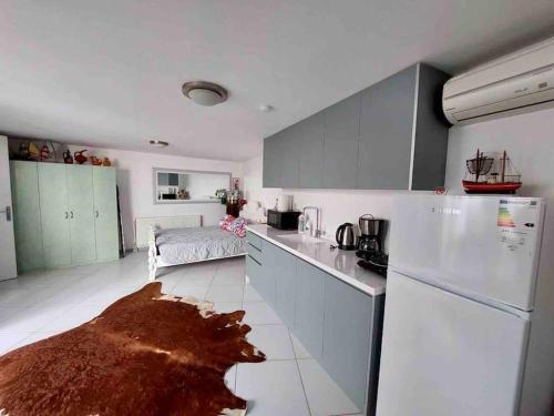 La cuisine est équipée de placards blancs et d'un réfrigérateur blanc. dans l'établissement Peacefull, Private, Pristine Studio Apartment, à Bodrum City