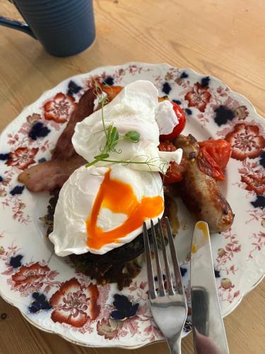 een bord met ontbijtproducten met eieren en spek bij The House with Two Front Doors in Rye