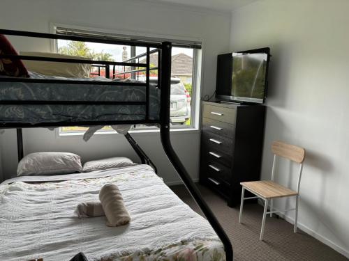 a bedroom with a bunk bed and a tv at Avondale Tidy Unit 1 in Auckland
