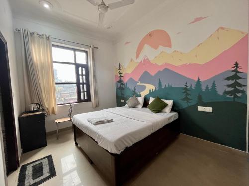 a bedroom with a bed with a mountain mural on the wall at Joey's Homestay in Rishīkesh
