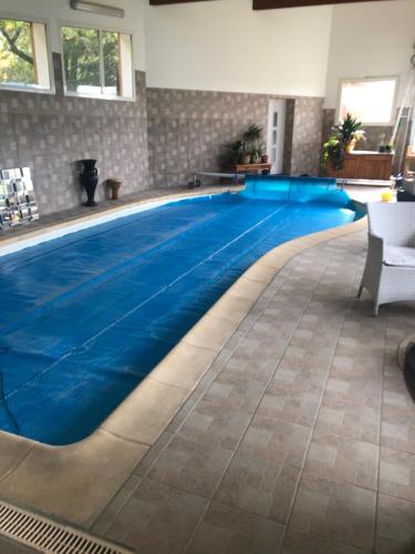 une piscine avec de l'eau bleue dans un immeuble dans l'établissement Chambre chez l'habitant, à Châteauvieux