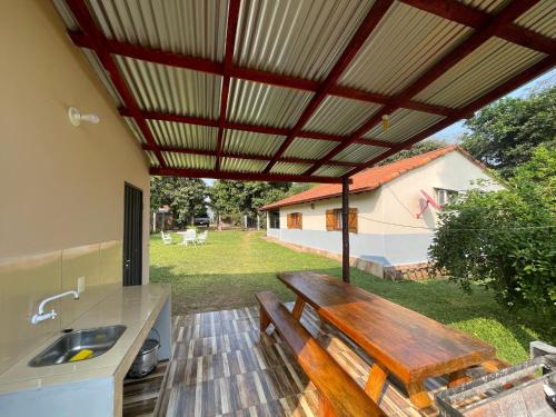 d'une terrasse avec un banc en bois et un évier. dans l'établissement Haus Independencia Guara Paraguay, 