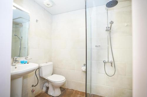 a bathroom with a shower and a toilet and a sink at Beaumonde Hotel Tbilisi in Tbilisi City