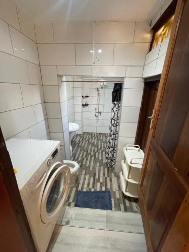 een badkamer met een wasmachine en een toilet bij Beautiful & Secured yellow House for 2 - Center of Osu in Accra