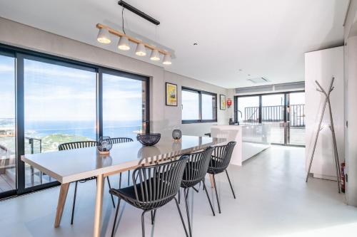 a kitchen and dining room with a table and chairs at House of Cork and Ivy - By WeHost in Câmara de Lobos