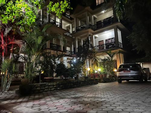 un'auto parcheggiata di fronte a un edificio di notte di Chitwan Park Village a Sauraha