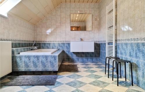 Cozy Home In Lo-reninge With Wifi في Lo-Reninge: حمام مع حوض استحمام وأرضية من البلاط