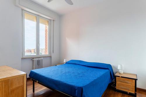 a bedroom with a blue bed and a window at Roomy Flat near the Hospital Riuniti with Parking! in Livorno