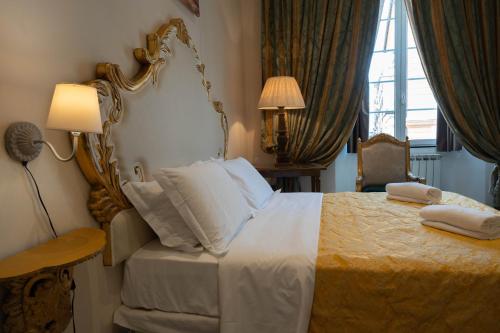 a bedroom with a large bed and a lamp and a window at San Giorgio Rooms in Genova