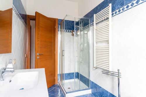 a bathroom with a glass shower and a sink at Roomy Flat near the Hospital Riuniti with Parking! in Livorno