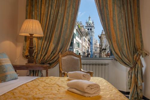 a hotel room with towels on a bed with a window at San Giorgio Rooms in Genova