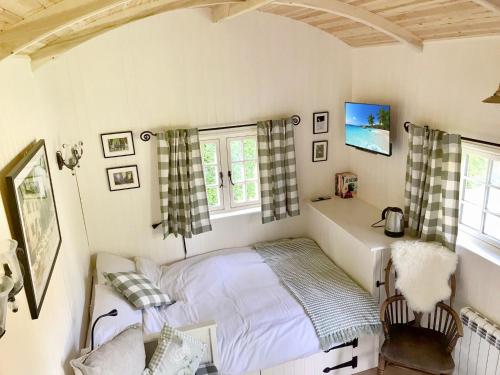 a bedroom with a bed and a chair in it at Beautiful Shepherd's Hut - Lois Weedon in Weston