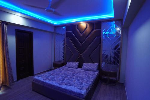 a bedroom with a bed with a blue light at 2 BED FURNISHED APARTMENT in Dhok Sandemār