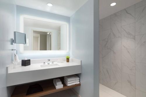 a bathroom with a white sink and a mirror at Courtyard by Marriott Boston Cambridge in Cambridge