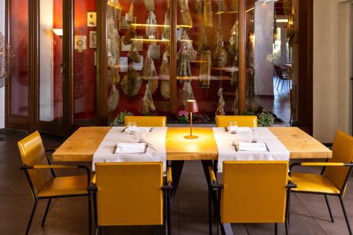 a dining room with two tables and yellow chairs at Best Western Modena District in Campogalliano