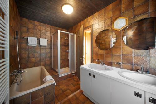 a bathroom with two sinks and a bath tub at Alt Montafon Hotel Appartements by Pferd auf Wolke in Gaschurn