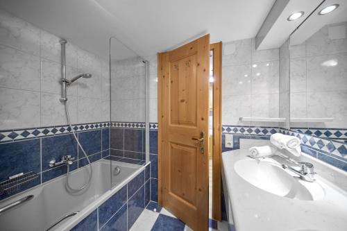 a bathroom with a tub and a sink and a shower at Alt Montafon Hotel Appartements by Pferd auf Wolke in Gaschurn