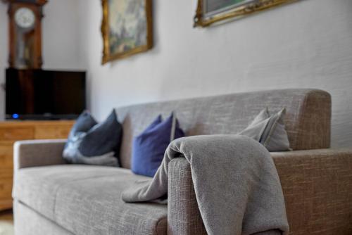 a couch with pillows and a blanket on it at Alt Montafon Hotel Appartements by Pferd auf Wolke in Gaschurn