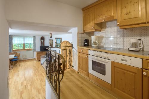 a kitchen with wooden cabinets and a white stove top oven at Alt Montafon Hotel Appartements by Pferd auf Wolke in Gaschurn