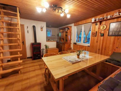 une salle à manger avec une table en bois et une échelle dans l'établissement Koča Kresnica, à Ilirska Bistrica