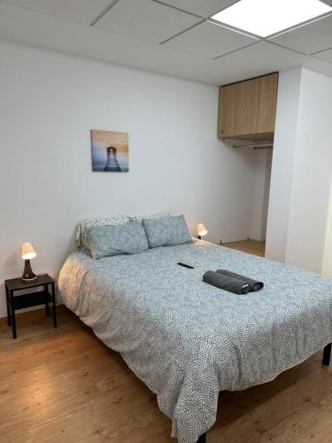 um quarto com uma cama grande e uma almofada. em Apartamentos Laborde em Madri