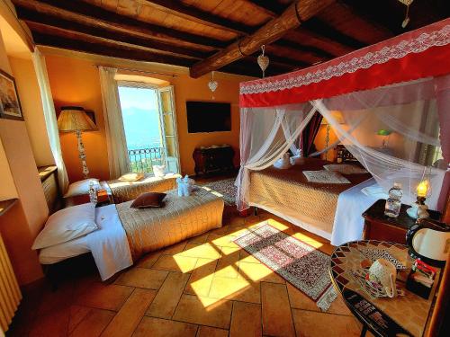 a bedroom with a canopy bed and a table at Antica Locanda La Tinara del Belvedere - Romantic Dreams - in Galbiate