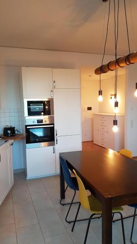 een keuken met een houten tafel en gele stoelen bij Penthouse Nähe Frankfurt am Main in Hanau am Main