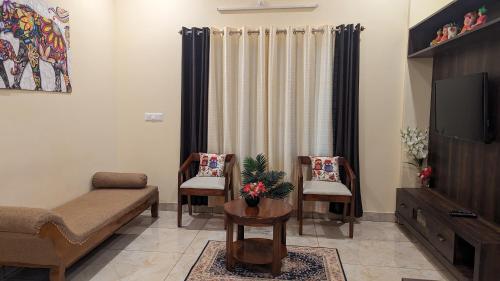 un soggiorno con divano e TV di SindooRa a Mysore