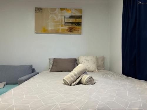 Una cama blanca con una almohada encima. en Mt Eden Tidy Unit B, en Auckland