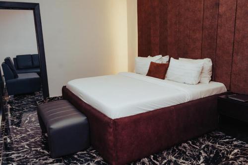 a bed in a hotel room with a mirror at Ovic Hotel in Benin City