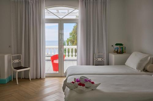 a bedroom with two beds and a balcony with a view at Inn & Art Madeira in Caniço