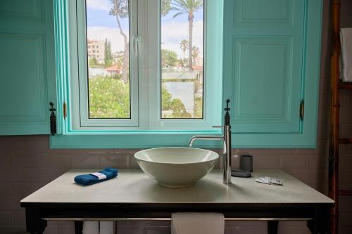 baño con lavabo y ventana en Inn & Art Madeira, en Caniço